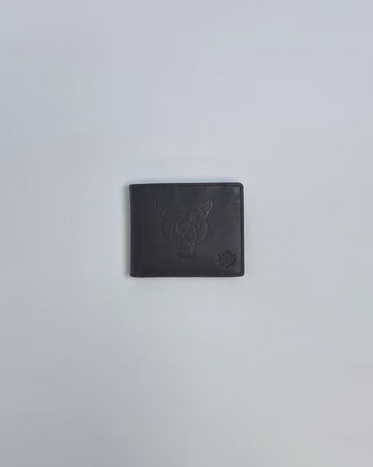 Karla Hanson Men's Mountain Lion Embossed Leather Wallet product video. Person places cash, cards, and change inside compartments in wallet.