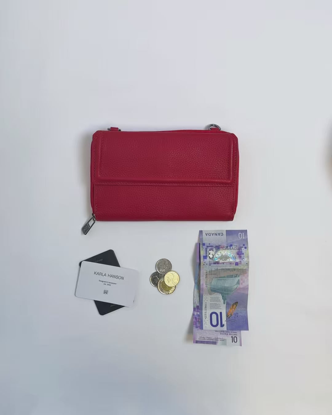 Karla Hanson women's Lorine Crossbody Wallet Leather in red product video. Person places cash, cards, and change inside compartments in wallet.