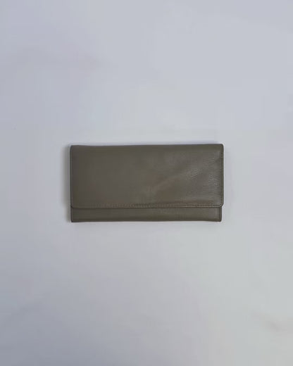 Karla Hanson Women's Trifold Wallet product video. Person places cash, cards, and change inside compartments in wallet.
