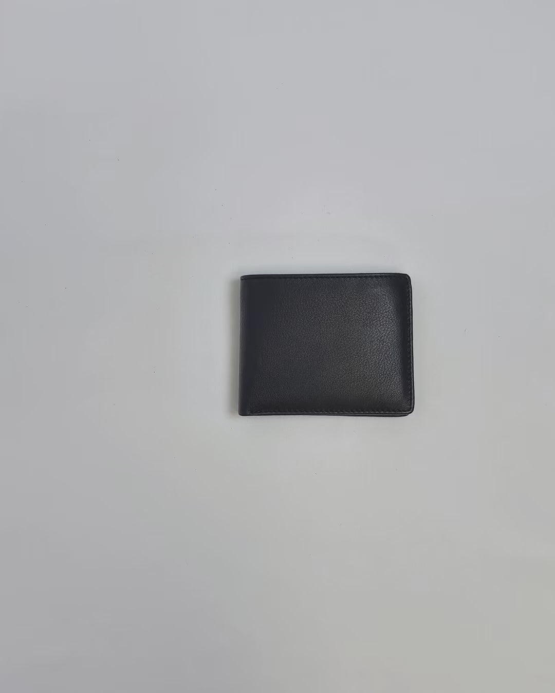 Karla Hanson Men's RFID Bifold Wallet Leather with Top Card Holder product video. Person places cash, cards, and change inside compartments in wallet.