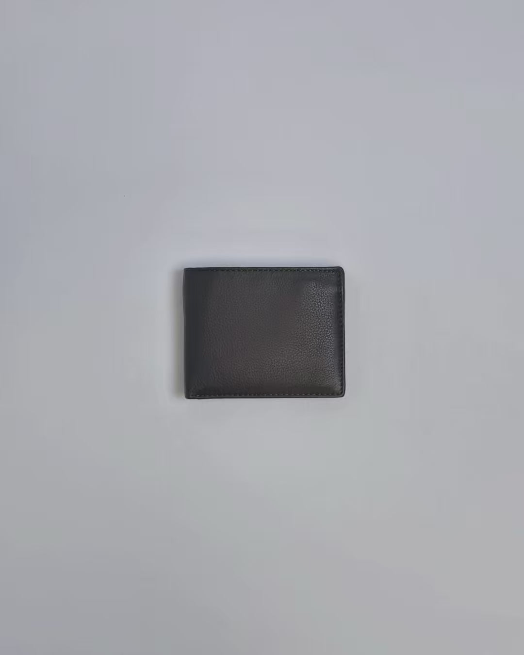 Karla Hanson Men's Leather Bifold Wallet with Coin Pocket product video. Person places cash, cards, and change inside compartments in wallet.