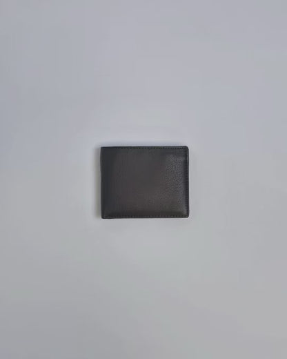 Karla Hanson Men's Leather Bifold Wallet with Coin Pocket product video. Person places cash, cards, and change inside compartments in wallet.
